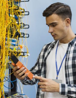 young-man-looking-fiber-optic-tester-medium-shot young-man-looking-fiber-optic-tester-medium-shot